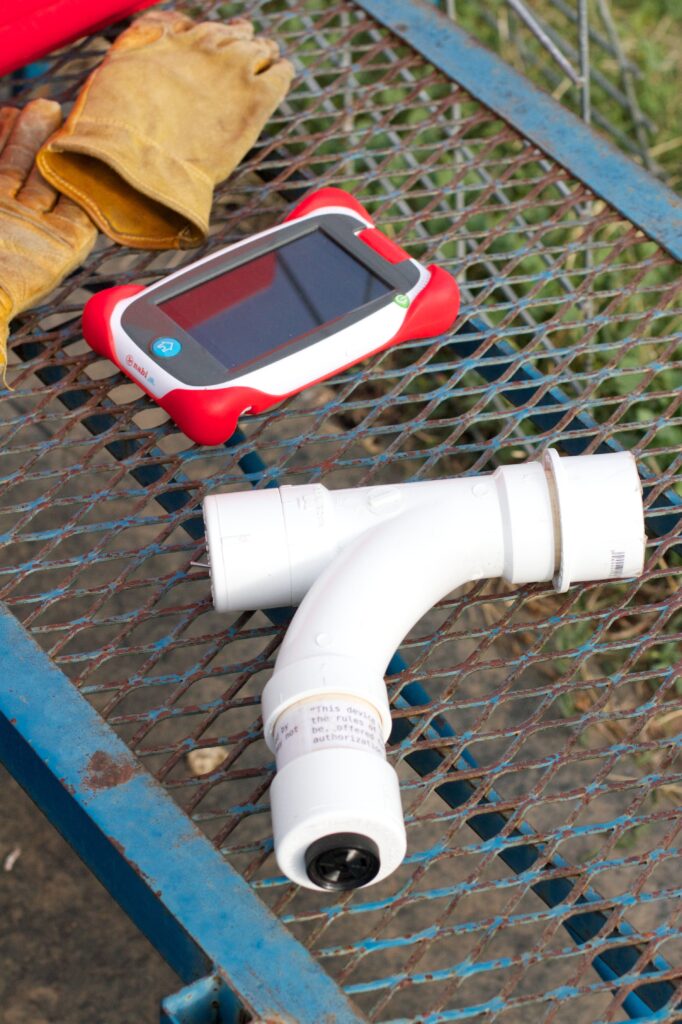 The homemade EID reader rests on a bench next to the early LambTracker® tablet.